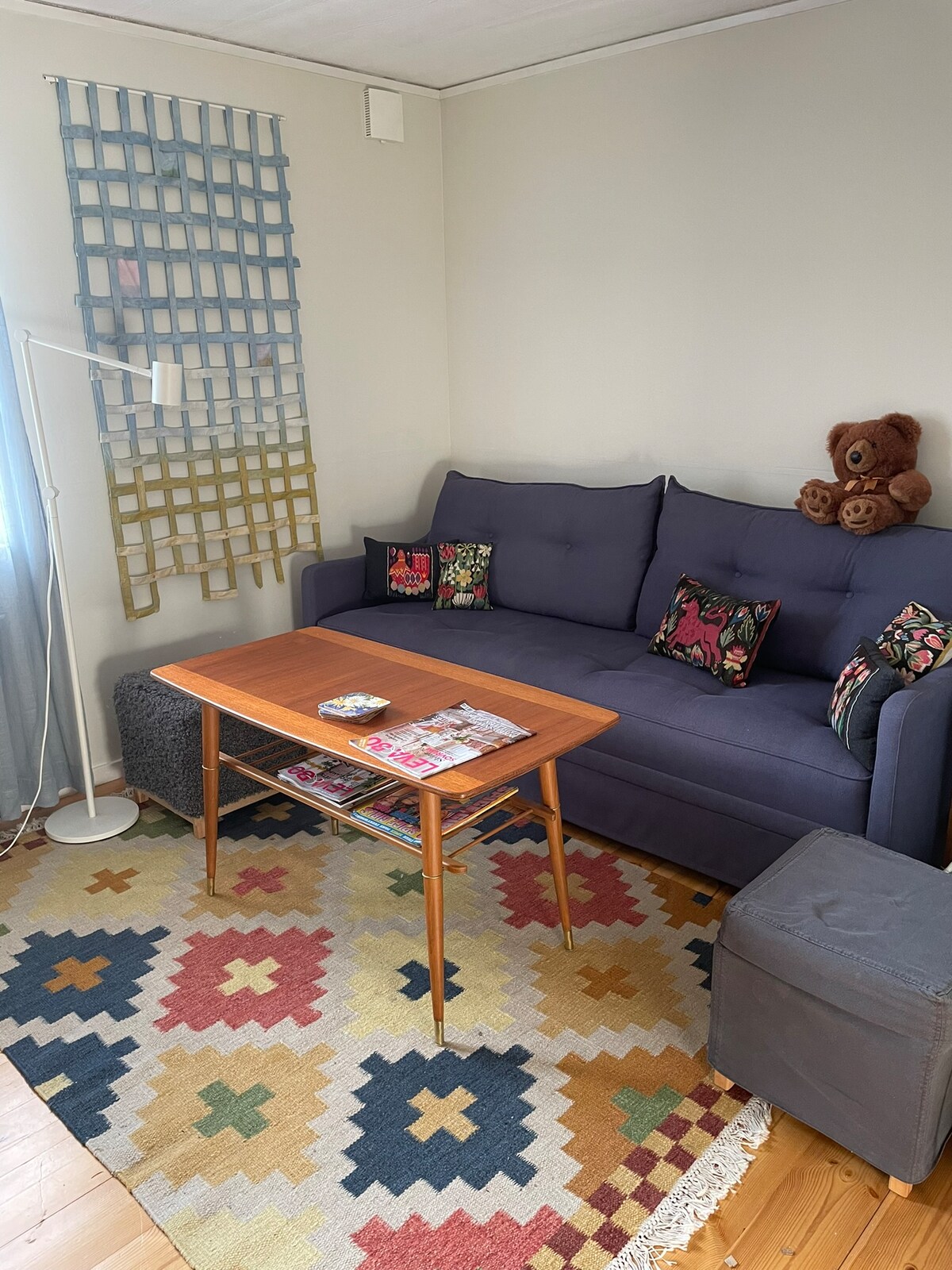 Living room with sofa and TV and a single bed.