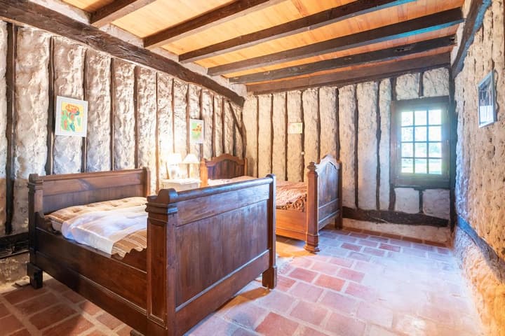 Kamer met ouderwetse charme – Dompel jezelf onder in een rustieke sfeer met deze vakwerkkamer, gesneden houten bedden en zacht natuurlijk licht voor rustige nachten.