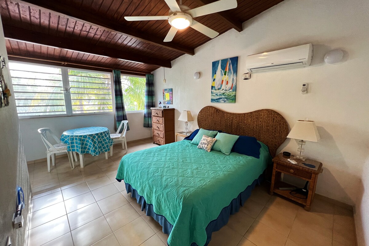 Климатизирана главна спалня с двойно легло, кът за сядане, самостоятелна баня.  Предпочитаме островния бриз пред климатичната инсталация, с малко помощ от вентилатора на тавана, когато е необходимо.