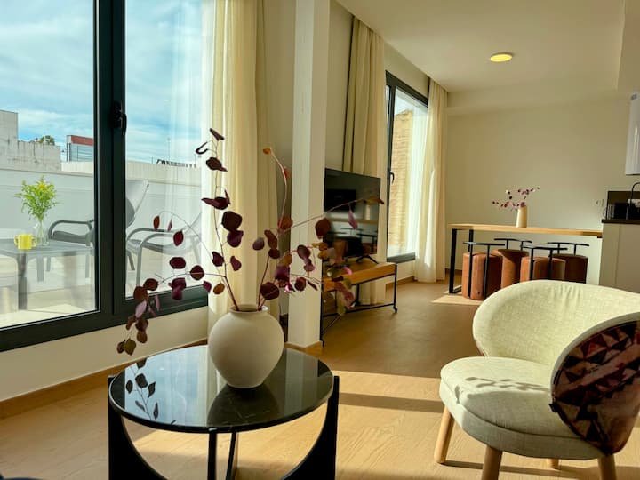 ห้องนั่งเล่นอาบแสงธรรมชาติ มีระเบียงส่วนตัว การตกแต่งที่มีสไตล์ และเฟอร์นิเจอร์ที่ใช้งานได้ดี ความแตกต่างระหว่างไม้ สิ่งทอ และแสงกลางแจ้งชวนให้คุณเพลิดเพลินกับบรรยากาศที่ทันสมัย อบอุ่น และสงบ