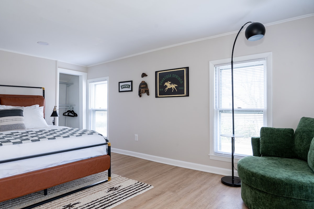 Bedroom 2 on second floor with queen bed, two closets (one with drawers) and round reading chair with overhead light. All upstairs bedrooms are equipped with 4 USB/ 4 outlet power strips on each bedside table. 