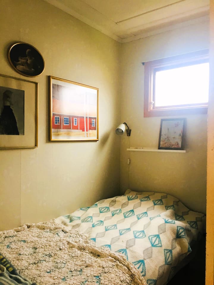 חדר שינה עם מיטת יחיד ושני ארונות בגדים.