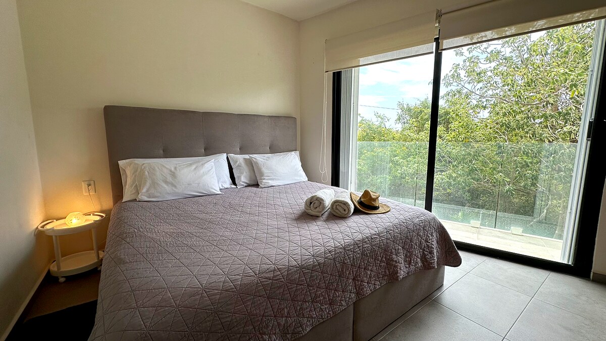 Основна спалня със суперголямо двойно легло, климатик, смарт телевизор, килер и самостоятелен балкон с изглед към природата.
