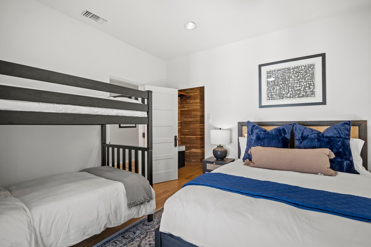 Deze uitnodigende slaapkamer beschikt over een groot queensize bed en een apart stapelbed met twee eenpersoonsbedden, een combinatie van diepe blauw en natuurlijke browns voor een rustgevende sfeer voor diepe rust en ontspanning. 