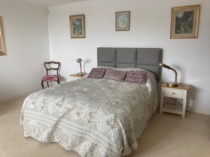 Вашиот удобен брачен кревет (широк 150-179 см) во оваа пространа спална соба