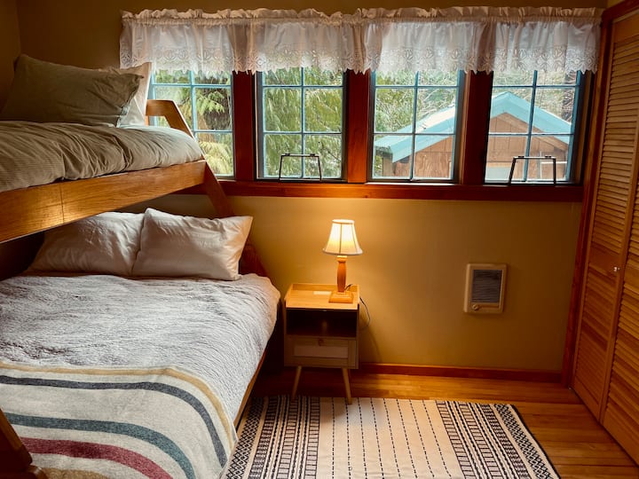 A comfy queen and twin bunk in the 2nd bedroom, with a closet. Side table includes USB and plugs for charging