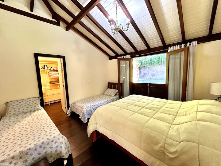 Habitación con cama tamaño queen y otras 2 camas individuales.  Armario y baño completo en el mismo patrón que las otras habitaciones