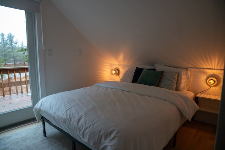 Dormitorio en la planta superior con cama tamaño queen y balcón