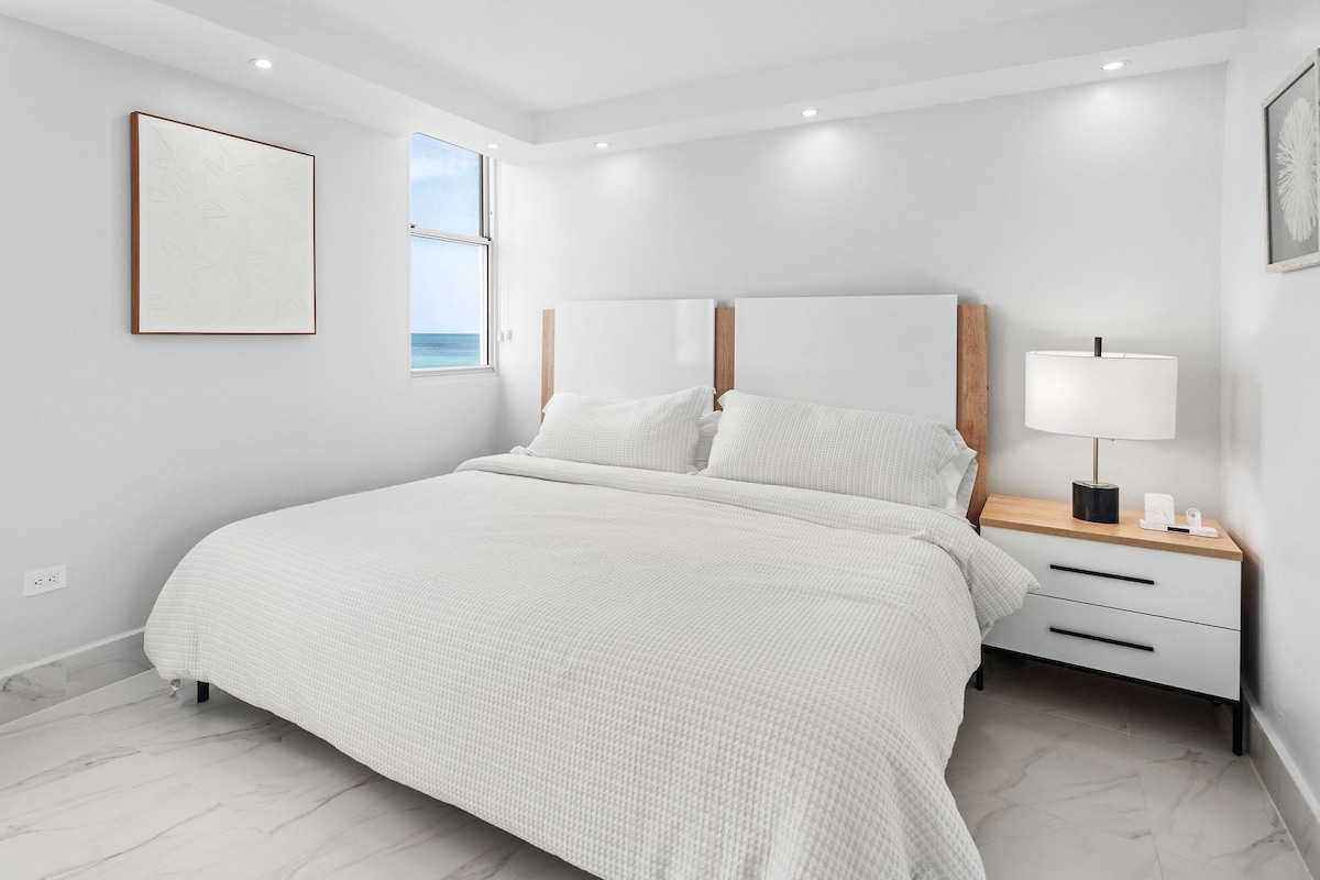 Elegantne zariadená spálňa s manželskou posteľou King a rozsiahlymi výhľadmi na oceán