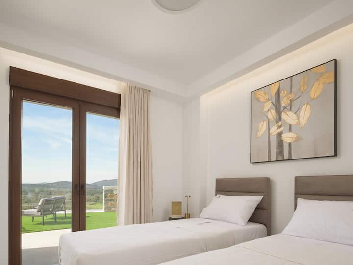 غرفة نوم مزدوجة تقع في الطابق الأرضي من ريزيدنس A، يمكن أن تشكل الأسرّة أيضًا سريرًا متوسط الحجم. 