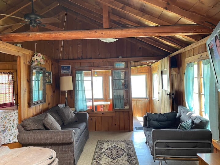 Divano letto futon, Apple TV appesa a schermo piatto. Lo sfondo è un portico sul retro schermato, con vista sul lungolago.