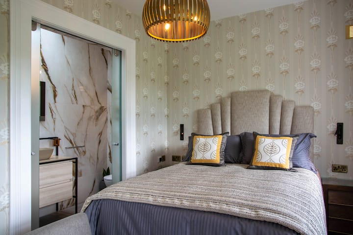 Naša spálňa pre hostí má manželskú posteľ veľkosti King s luxusným čelom a svetlami na čítanie na každej strane !