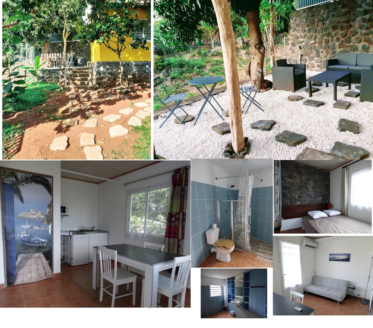 A private garden area is visible, featuring a stone pathway leading to a seating arrangement composed of two chairs and a table. The interior includes a functional kitchen space with a dining table and chairs, along with a clean bathroom showcasing a shower. A cozy sleeping area is lined with light-colored bedding.