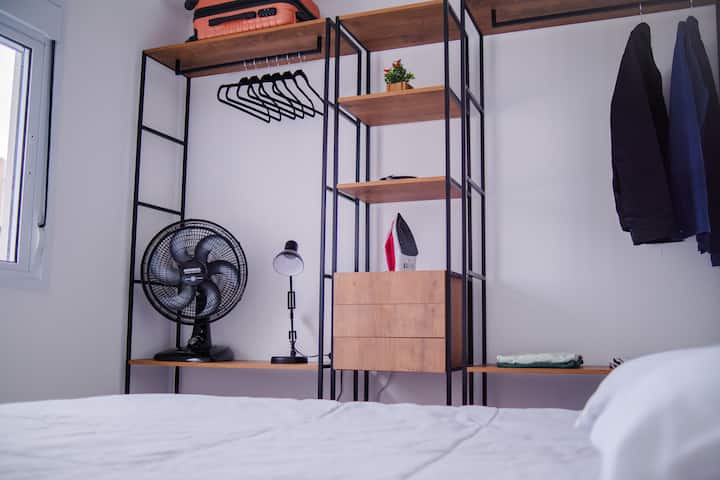 KAMER SUITE met: tweepersoonsbed + industriële kast + industrieel schoenenrek + handtassen + ventilator + lampenkap + bed- / badlinnen en kleerhangers.