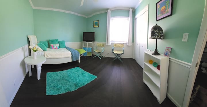 Un pequeño tema de playa en este dormitorio que cuenta con una cama individual y televisión por cable. 