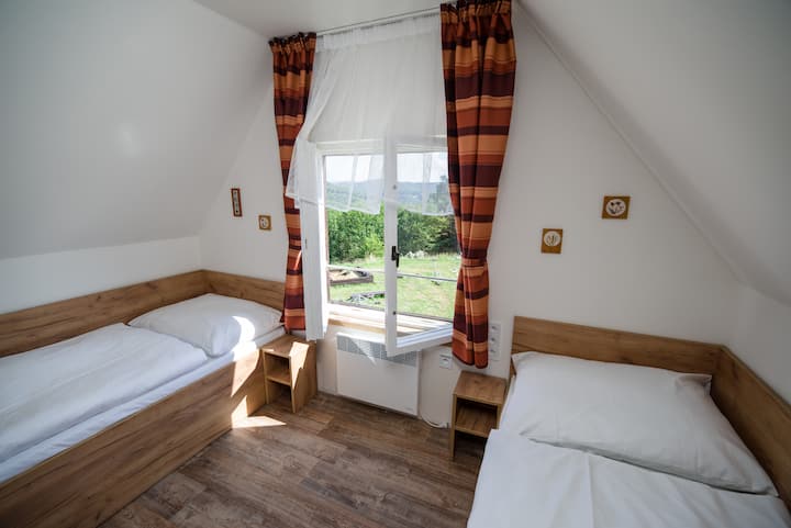 Dhoma e gjumit me katër krevate tek ndodhet në katin e parë përballë sallës me një dhomë gjumi me dy krevate. Dhoma ka gjithashtu një dritare me pamje nga këndi i lojërave.