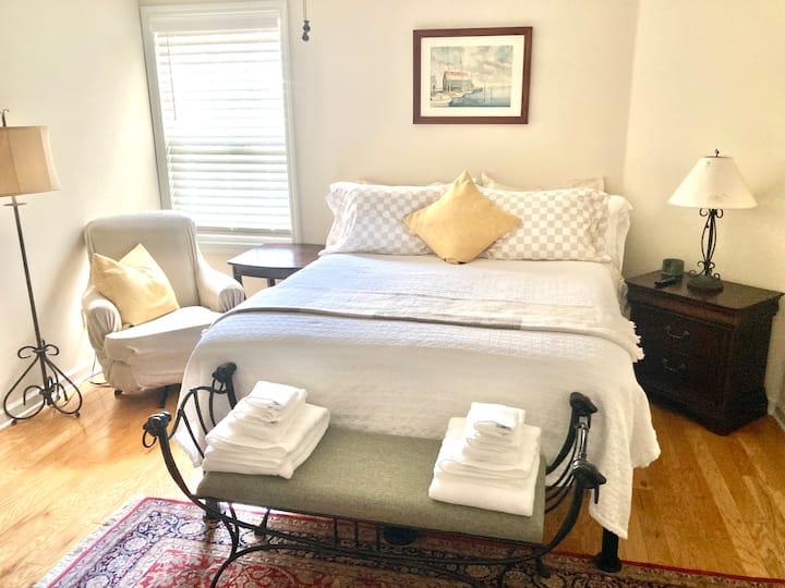Your bright, clean, and peaceful private suite features a comfy queen bed, wall mounted smart TV, and attached full bathroom.