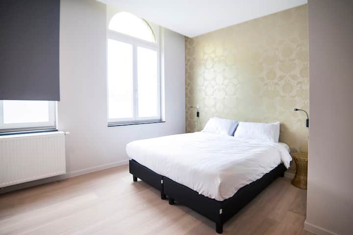 חדר שינה עם מיטה זוגית, רדיאטור לשידה ליד המיטה
