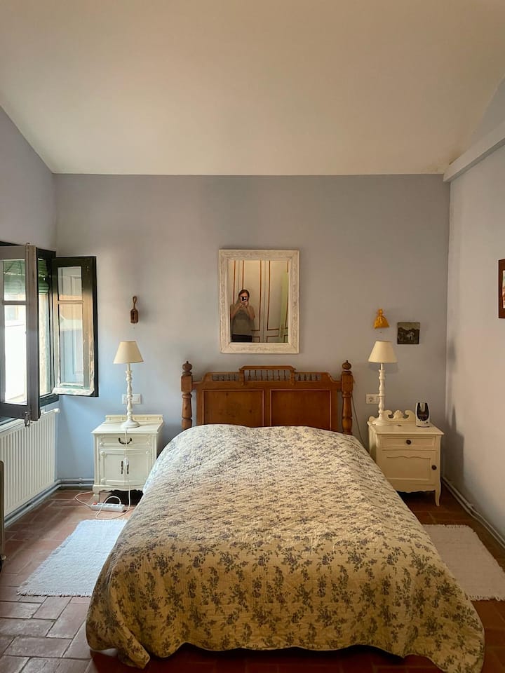 Hlavná spálňa s manželskou posteľou Queen, dvoma nočnými stolíkmi, dvoma lampami, zrkadlom a čelo postele.