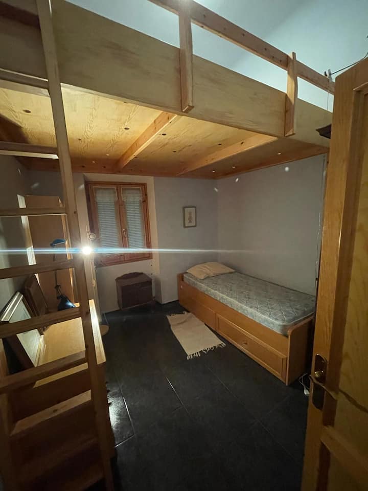 Detská izba: jednolôžko, ventilátor, medziposchodie, písací stôl a starý šatník.