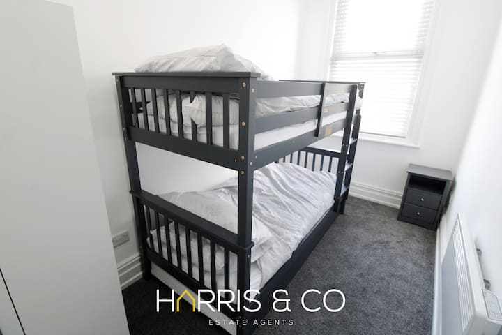 تتسع الشقة لنوم 4 أشخاص مع غرفتي نوم، إحداهما بسرير مزدوج والغرفة الأخرى بسرير بطابقين رمادي حديث وطاولة بجانب السرير وسخان كهربائي وخزانة ملابس لسهولة التخزين.