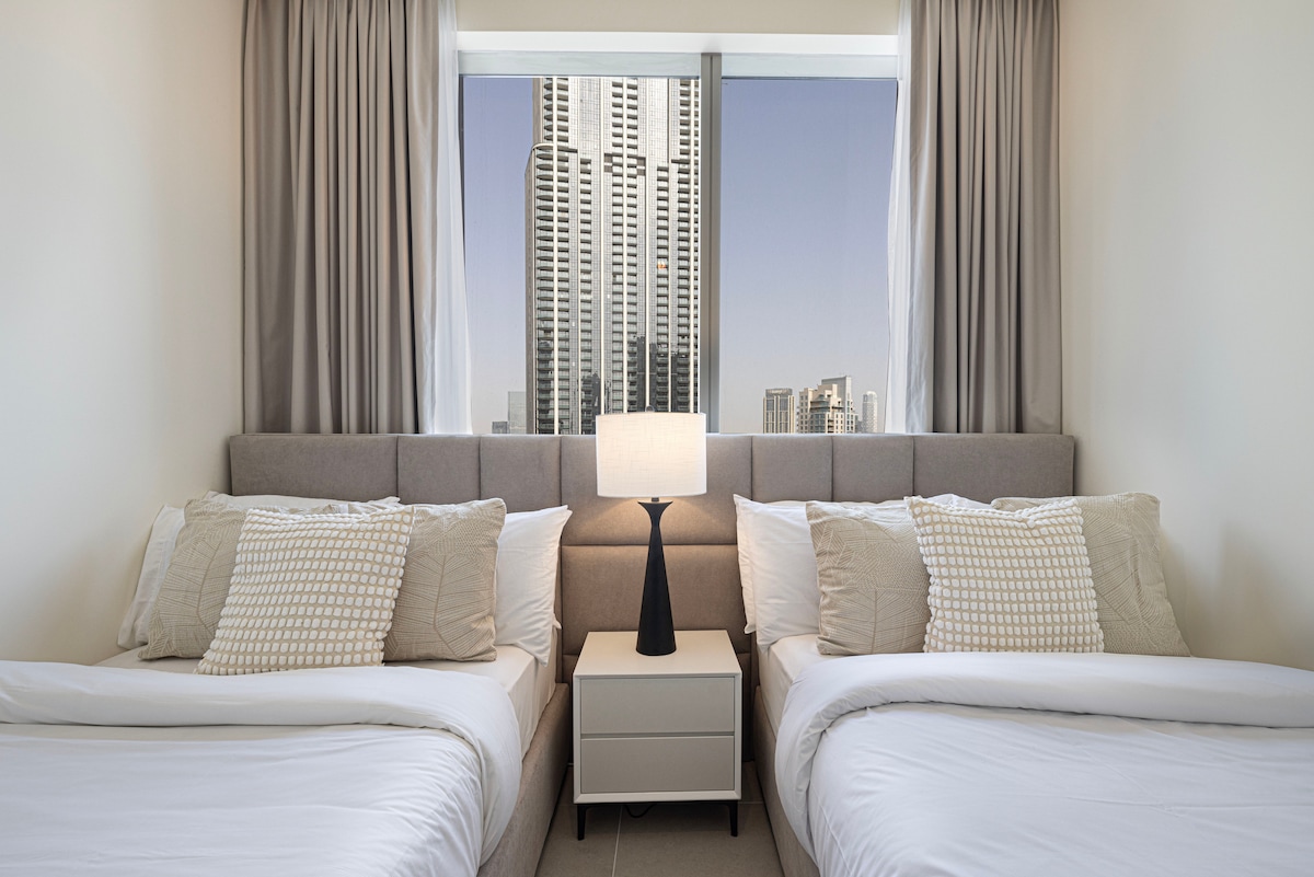 Sumérgete en sueños con vistas: nuestro acogedor dormitorio ofrece impresionantes vistas del horizonte de la ciudad, incluyendo el Burj Khalifa, la Ópera de Dubái y las fascinantes fuentes. Relájate cómodamente con dos camas matrimoniales cómodas (120 cm de ancho), lo que garantiza un descanso tranquilo