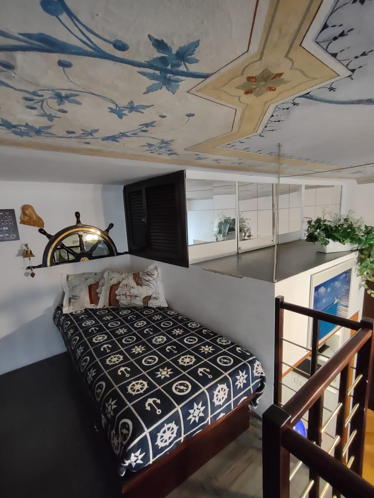 夹层的单人床通往客厅，配有壁画天花板