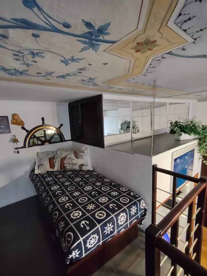 Krevet za jednu osobu na međuspratu s dnevnim boravkom i stropovima s freskama