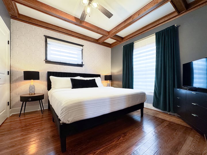 Dormitorio en el primer piso con cama tamaño king y TV inteligente de pantalla plana.