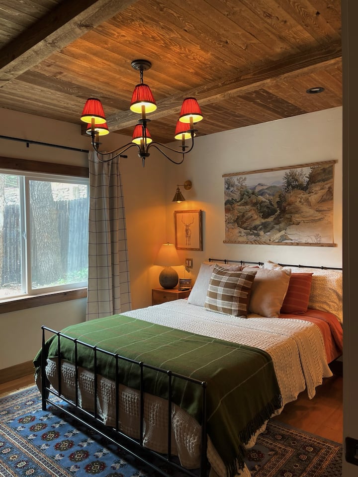 The main bedroom is equipped with a comfy queen size bed, a Roku TV with Youtube TV and HBO Max connections, various dimmable lighting options, a full sized closet, and blackout curtains for privacy.