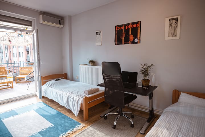 Habitación con dos camas individuales que tiene una salida directa a la terraza.