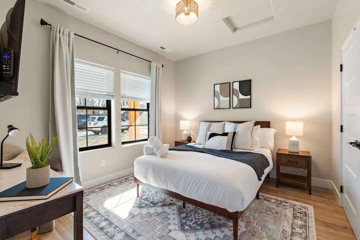 Насладете се на спалнята с двойно легло queen size, с изключително удобен матрак Ghost, луксозно спално бельо от 100% памук в хотел, телевизор Roku и щедро място за съхранение на дрехи.