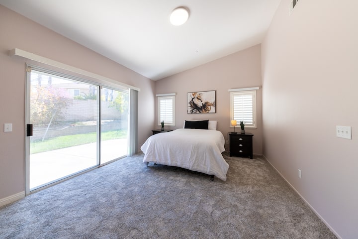 Dhomë gjumi kryesore me një krevat dopio "queen", e plotësuar nga një dritare e bukur që ofron një pamje relaksuese të kopshtit.