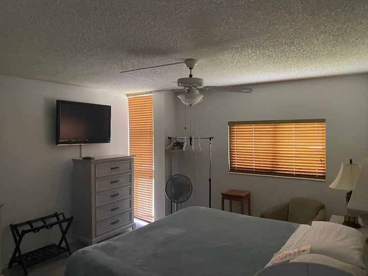 Útulná spálňa s prirodzeným svetlom, manželskou posteľou veľkosti King a televízorom; pokojný priestor na oddych po slnečných dňoch.