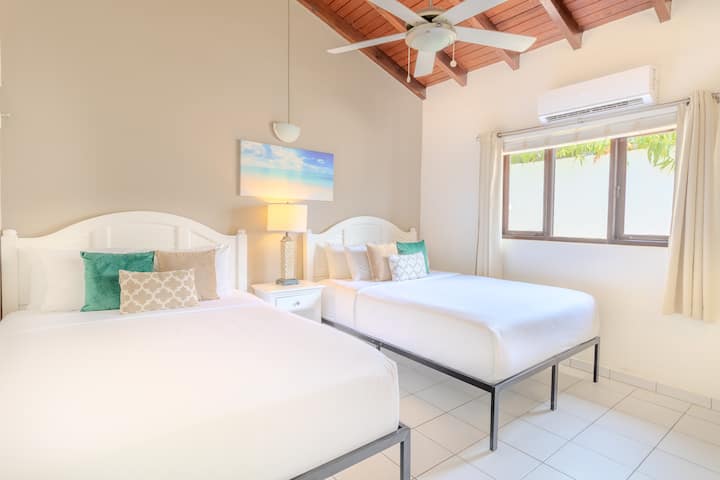Bedroom 2 | Sink into the comfort of not one, but two queen-size beds, ensuring ample space for a rejuvenating night's sleep. Entertainment awaits with a convenient TV setup, making it the ideal spot for unwinding after a day of adventure.