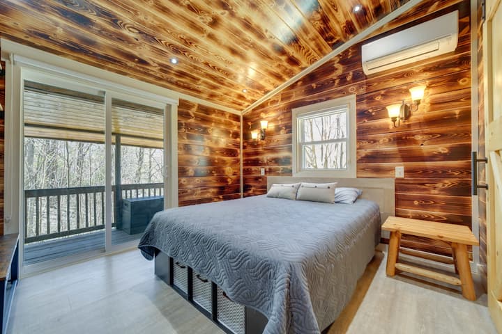 غرفة نوم رئيسية بسرير كبير وباب زجاجي منزلق.