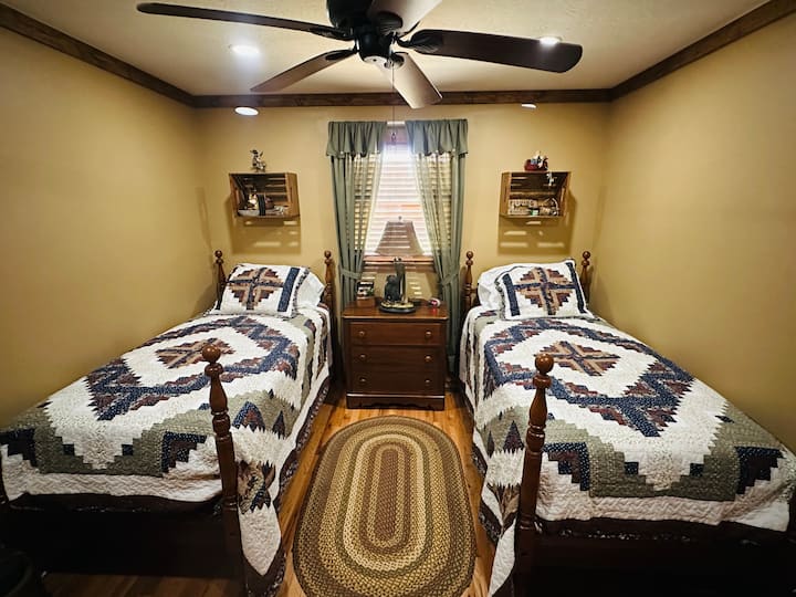 غرفة نوم للضيوف بسريرين مزدوجين وفراش جديد وخزانة ملابس وخزانة ملابس وتلفزيون ذكي وطاولة جانبية