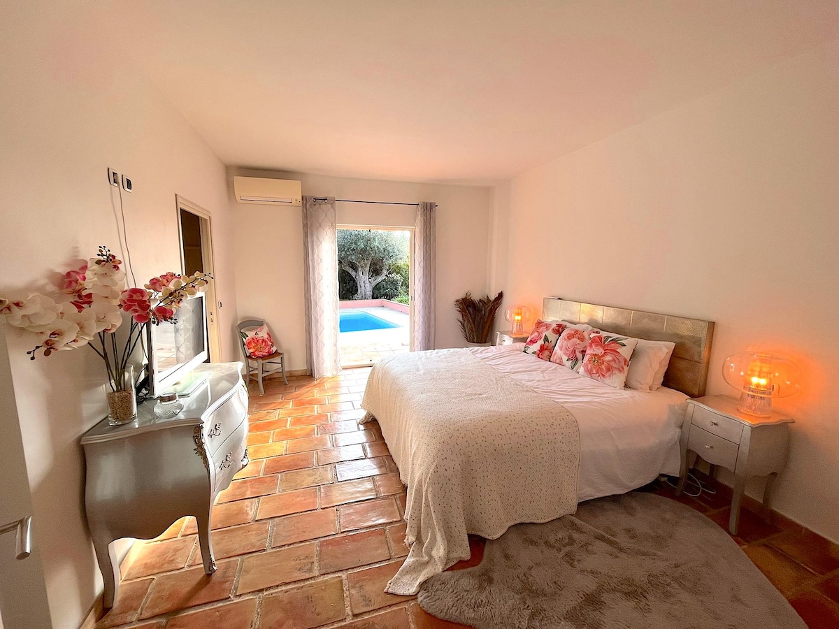 Slaapkamer met eigen badkamer en uitzicht op het zwembad