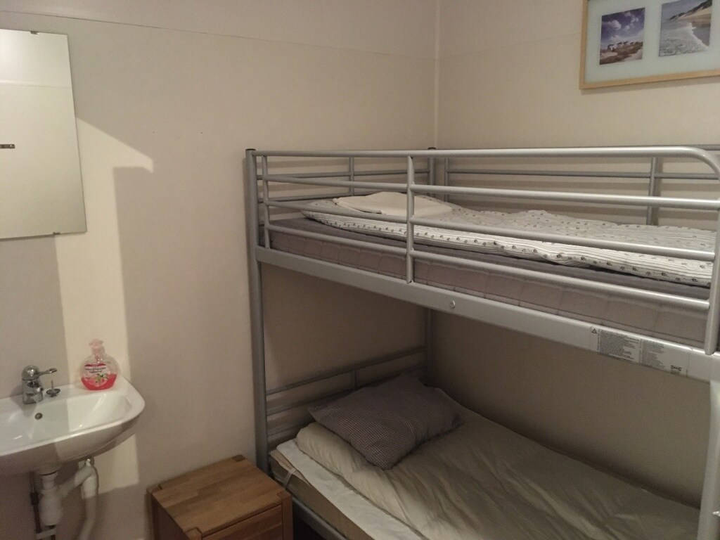 חדר שינה קטן למטה עם מיטת קומותיים 