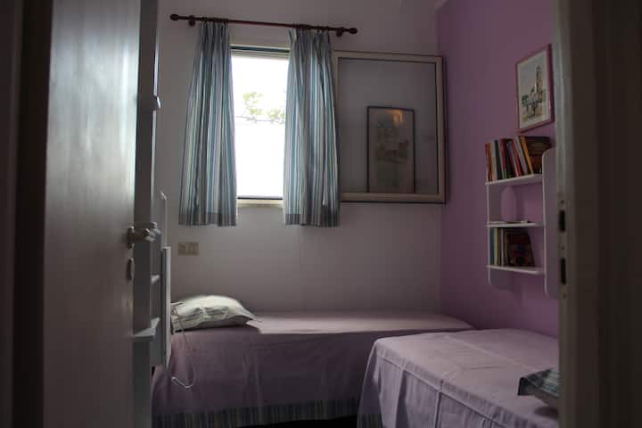 Vitanda viwili vya mtu mmoja katika chumba hiki havina ukubwa wa kawaida: vina urefu wa 1.70 na upana kama kitanda cha kawaida cha mtu mmoja