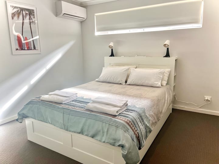 חדר שינה ראשי עם מזגן, מיטת קווין סייז, מזרן קואלה סופר נוח, מגירות מתחת למיטה לאחסון וארון מובנה גדול.