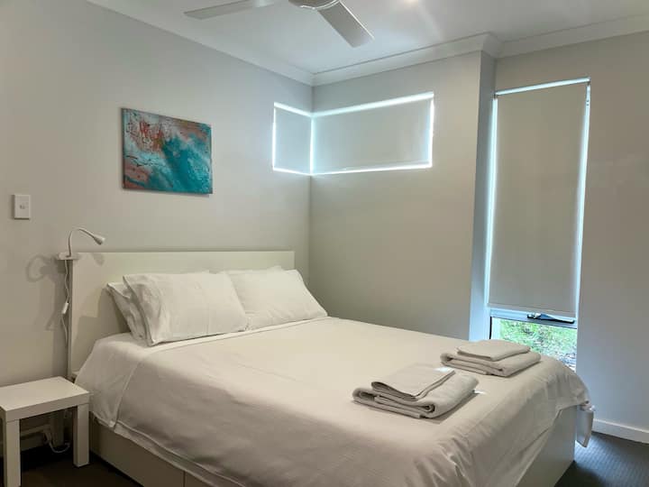 חדר אורחים 1 עם מיטת קווין סייז, מזרן קואלה נוח במיוחד, אחסון מתחת למיטה, ארון קיר גדול מובנה, מאוורר, לוח חשמל ואור מיטה. 