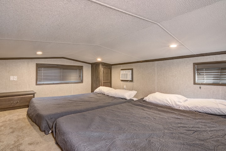 Dormitorio elevado en la planta superior con dos camas dobles 