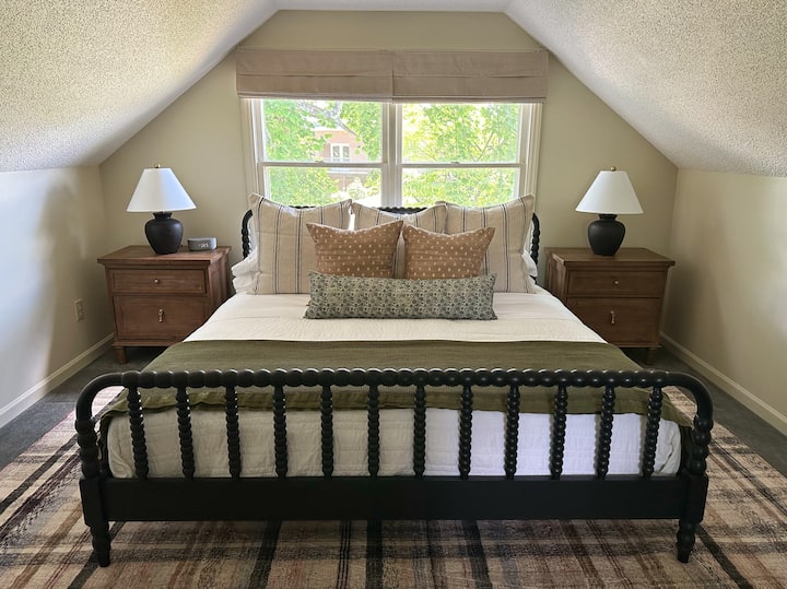 Dormitorio en planta alta con espaciosa cama tamaño king, tocador y amplio espacio en el armario con portaequipajes.