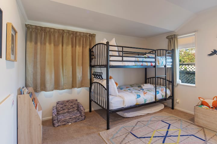 Dormitorio 3 (nivel principal): literas individuales con libros, juguetes, jardín y algunas vistas al mar.