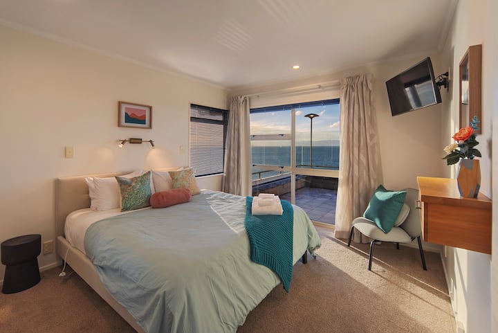 Dormitorio 2 (principal; nivel principal): cama tamaño king con vistas completas al mar y acceso directo a la terraza.