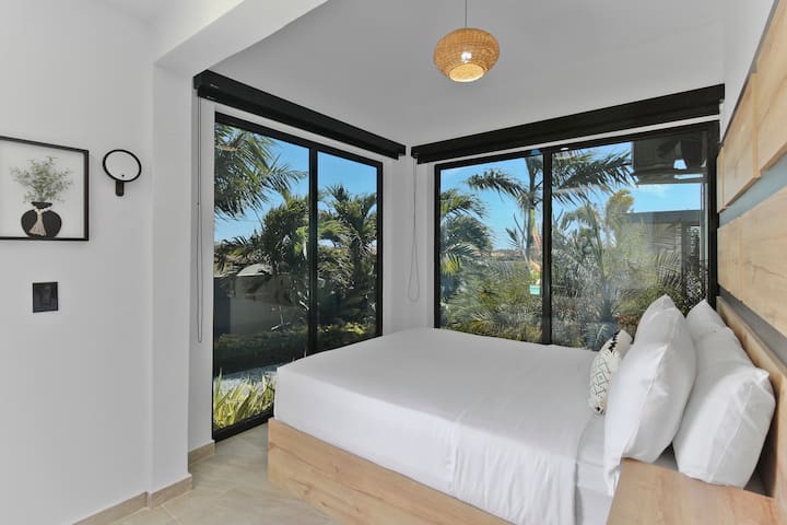 Quinto dormitorio | Con ventanas negras teñidas, puedes disfrutar de total privacidad mientras disfrutas del hermoso entorno natural, creando un ambiente sereno y tranquilo perfecto para la relajación. El quinto dormitorio cuenta con 2 camas tamaño queen.