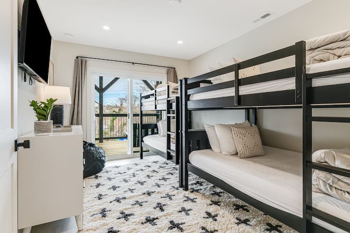 Mwonekano wa kona wa Chumba cha kulala cha 5 chini na vitanda 4 pacha vya ghorofa, sehemu kubwa ya kabati, Televisheni ya Smart Roku na kabati la kujipambia