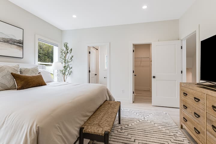 Picha ya karibu ya chumba kikuu cha kulala na bafu kuu lililoambatishwa na kabati la kuingia