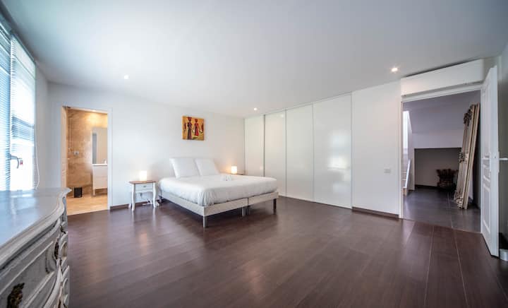 Gran habitación amplia y luminosa con cama doble, sábanas suaves y espacio de almacenamiento